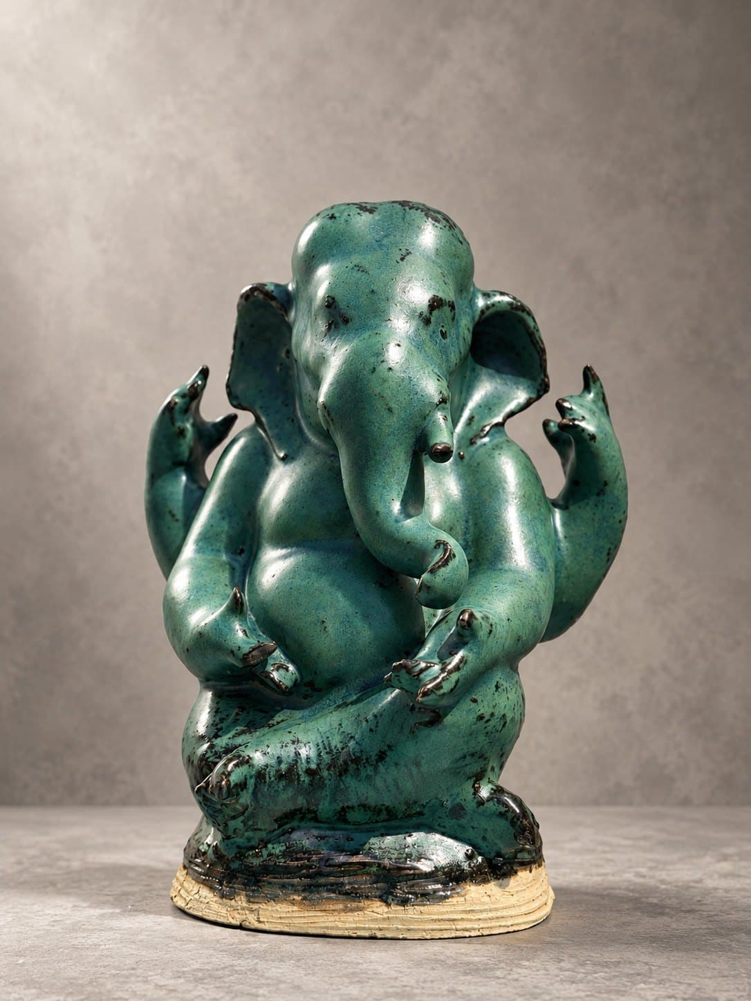ชื่อ: Untitled * SEO Title (EN): Untitled – Ceramic Sculpture by Watcharin Chumek * SEO Title (TH): Untitled – ประติมากรรมเซรามิก วัชรินทร์ ชูเมฆ * Meta Description (EN): A seated four-armed Ganesha in speckled jade-green glaze, softly rounded yet anatomically assured. An original devotional sculpture by Thai sculptor Watcharin Chumek. * Meta Description (TH): พระพิฆเนศประทับนั่ง สี่กร เคลือบสีเขียวหยกลายจุด รูปทรงอ่อนช้อยแต่มั่นคงด้วยความเข้าใจกายวิภาค ประติมากรรมรูปเคารพต้นฉบับร่วมสมัย โดยวัชรินทร์ ชูเมฆ * Alt Text (EN): Seated four-armed Ganesha ceramic sculpture in speckled jade-green glaze on a textured unglazed clay base * Alt Text (TH): ประติมากรรมเซรามิกพระพิฆเนศประทับนั่ง สี่กร เคลือบสีเขียวหยกลายจุดดำ บนฐานดินดิบผิวลายเส้น * URL slug: watcharin-chumek-jade-ganesha-sculpture * Keywords (EN): Ganesha sculpture, ceramic Ganesha, green Ganesha statue, contemporary Ganesha art, Thai devotional sculpture, original sculpture for sale * Keywords (TH): พระพิฆเนศ, องค์พระพิฆเนศเซรามิก, พระพิฆเนศสีเขียว, รูปเคารพร่วมสมัย, ประติมากรรมศิลปินไทย, บูชาพระพิฆเนศ
